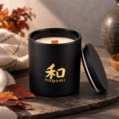 Autumn's Sigh candle with wood wick and black lid in a warm fall setting with autumn leaves