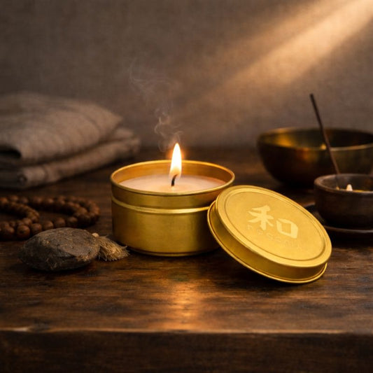 Lit Dragon’s Whisper mini-tin candle in a gold metal tin, shown in a calm, meditative indoor setting.”