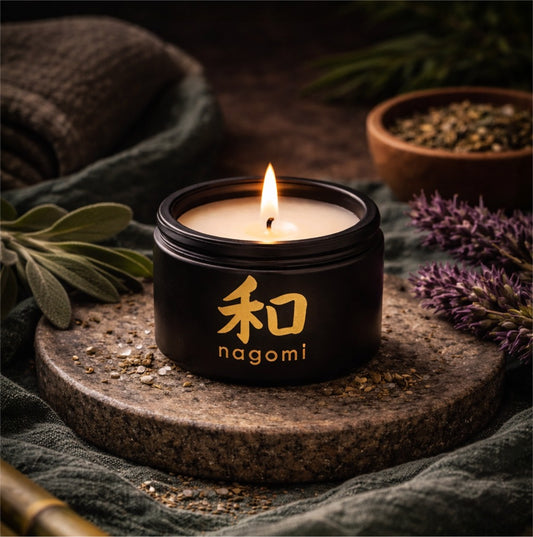 4 oz Nagomi Woodland Dream candle glowing on a stone surface with casaba melon, bamboo, and deep violet floral accents