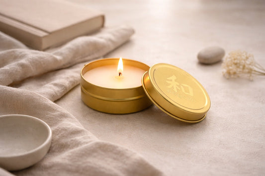 Lit Nagomi mini-tin candle on a neutral surface, styled for a calming anxiety-relief ritual