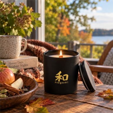 An Autumn's Sigh candle with wood wick burning beside an open window as summer turns to fall