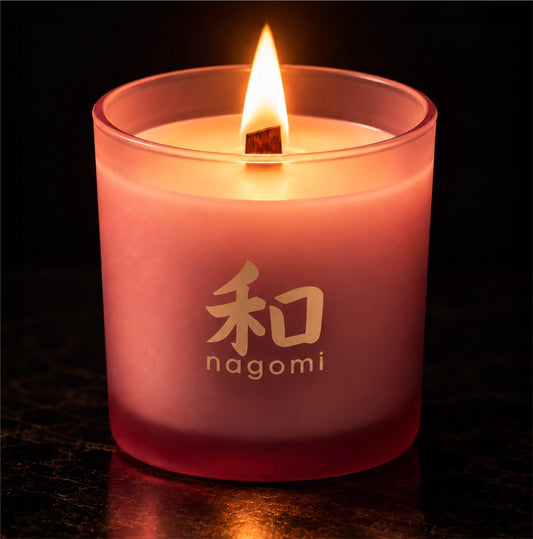 Fierce Ember candle with wood wick burning in a frosted rose glass vessel against a dark background