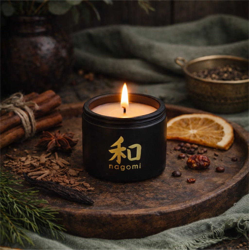 4 oz Nagomi Dragon’s Whisper candle glowing outdoors with orange fruit, cedarwood shavings, and tonka bean accents
