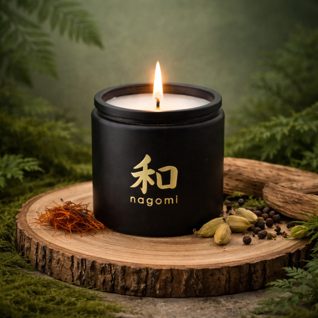 Close-up of a lit 12 oz Nagomi candle with cardamom seeds and saffron nearby