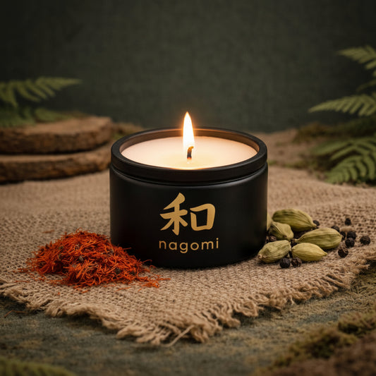 4 oz. Nagomi Sacred Balance candle glowing among saffron threads, cardamom pods, and sandalwood outdoors