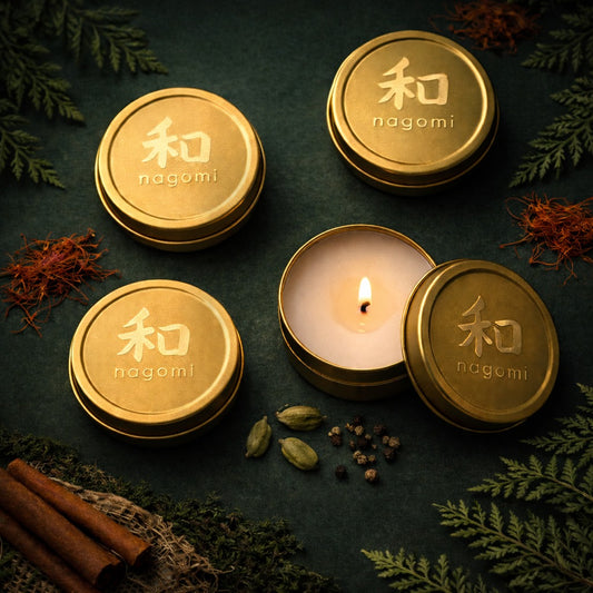 Lit Nagomi Sacred Balance mini-tin candles surrounded by saffron, cardamom, and sandalwood