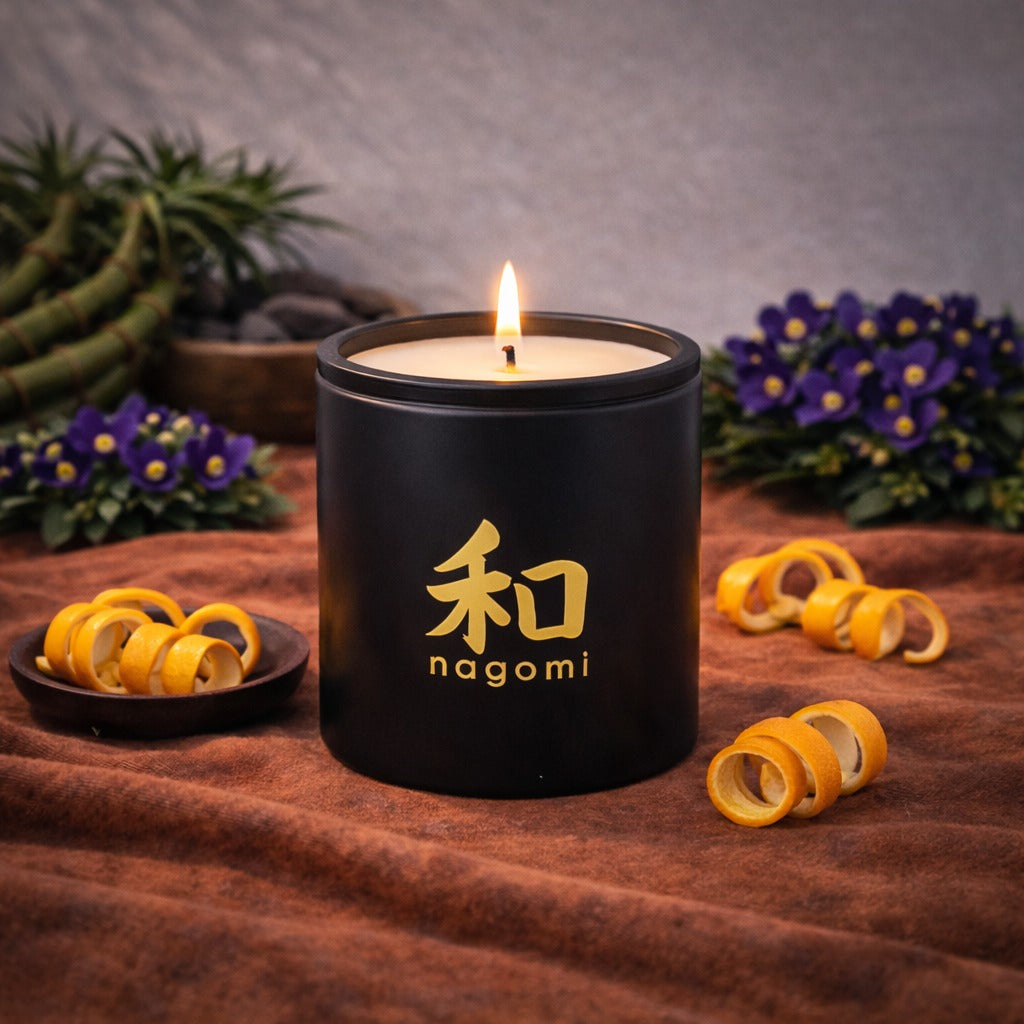12 oz Nagomi Bamboo Breeze candle in a black glass container with orange peels, bamboo stalks and African violets