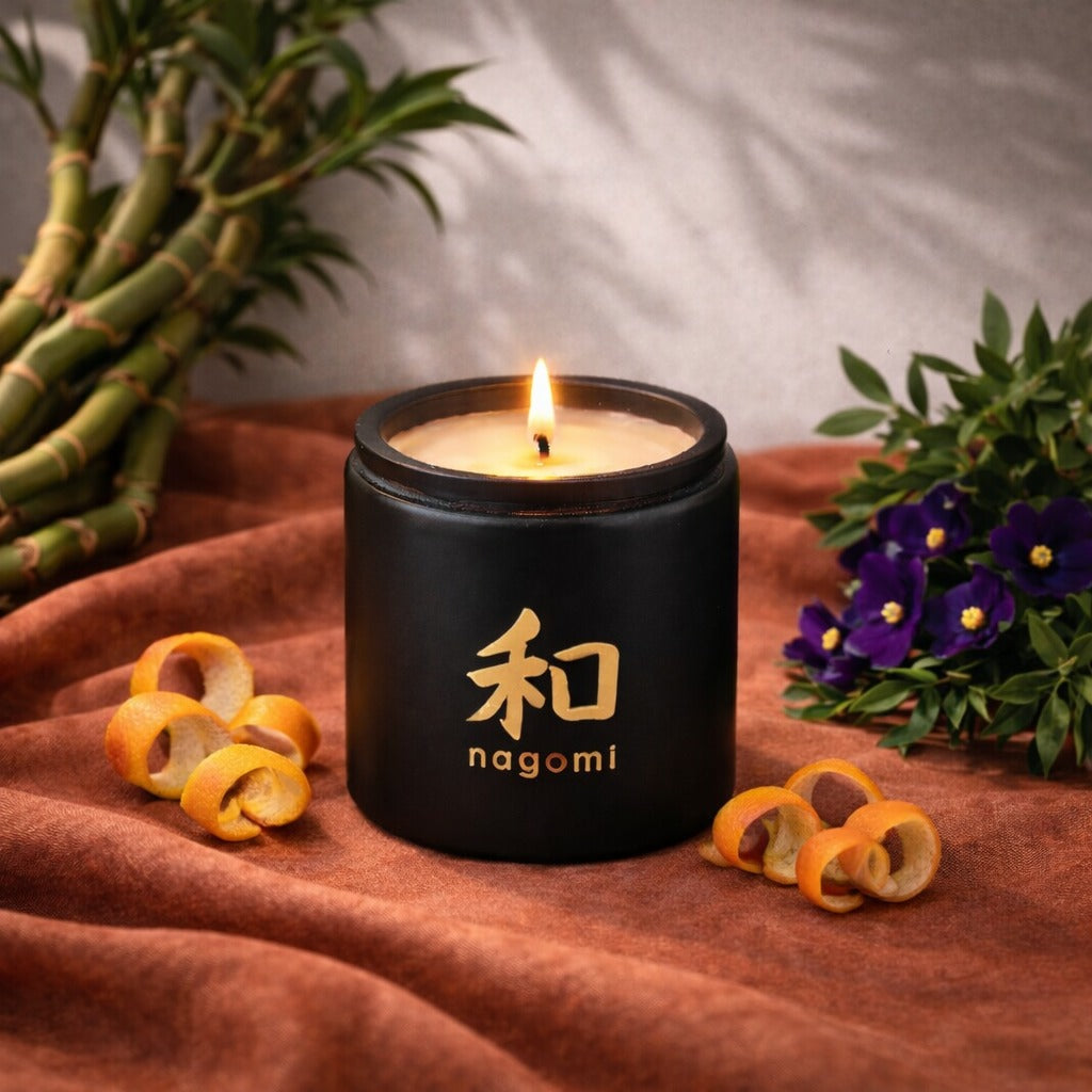 8 oz Nagomi Bamboo Breeze candle in a black glass container with orange peels, bamboo stalks and African violets