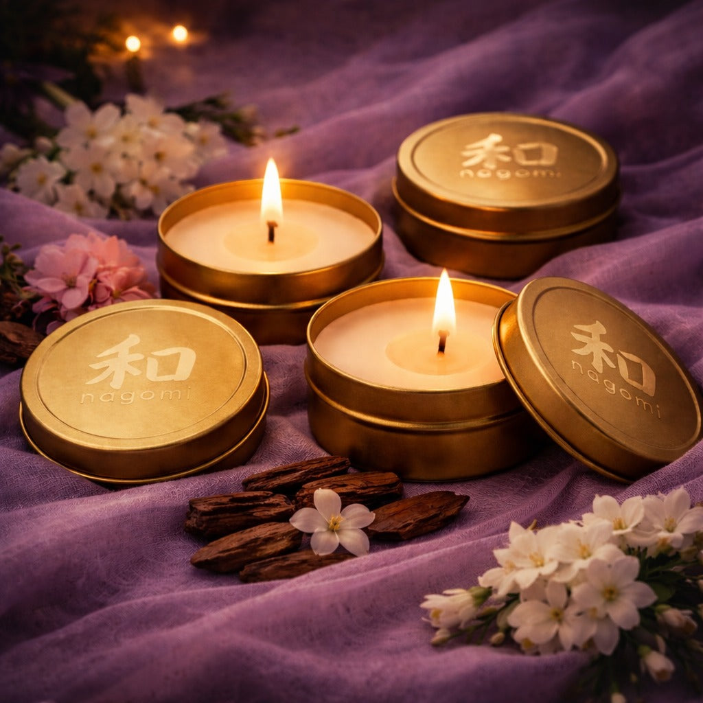 Nagomi Mystic Alchemy mini-tin candles in gold tins with Jasmine, geranium and teakwood in the background